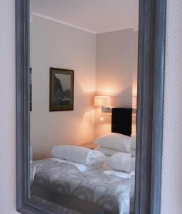 a mirror reflection of a bed in a room at Havila Hotel Geiranger in Geiranger