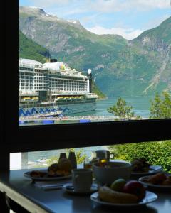 a table with a view of a cruise ship at Havila Hotel Geiranger in Geiranger