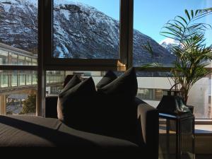 a living room with a couch in front of a window at Havila Hotel Geiranger in Geiranger