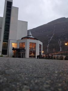 a large building with a mountain in the background at Havila Hotel Geiranger in Geiranger