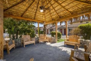 um pavilhão de madeira com três cadeiras sob um telhado em Rodeway Inn near Coachella em Indio