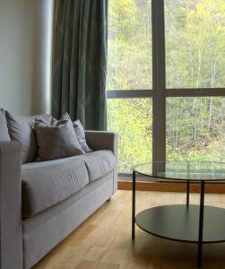 a living room with a couch and a glass table at Havila Hotel Geiranger in Geiranger