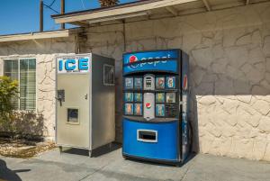 dos máquinas están estacionadas al lado de un edificio en Rodeway Inn near Coachella en Indio