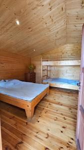 um quarto com 2 camas num chalé de madeira em J&L GRADZKIE em Grądzkie