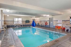 uma grande piscina com cadeiras e uma mesa em Comfort Inn & Suites em Dover