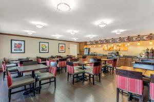 a restaurant with tables and chairs and a bar at Comfort Inn & Suites in Dover