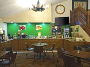 a restaurant with tables and chairs and a clock on the wall at Quality Inn Atchison in Atchison