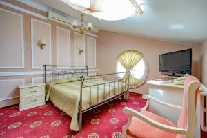 a bedroom with a bed and a desk with a computer at Gostiniy Dvor in Odesa