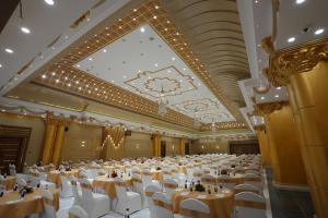 a large banquet hall with white tables and chairs at The Royal Bihar in Patna