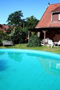 a large blue swimming pool in front of a house at Ferienwohnungen Bauernhof Beckmann in Winsen Aller