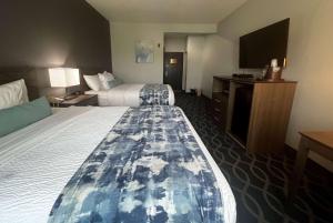 a hotel room with two beds and a flat screen tv at Wingate by Wyndham Humble/Houston Intercontinental Airport in Humble