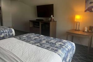 a hotel room with a bed and a flat screen tv at Wingate by Wyndham Humble/Houston Intercontinental Airport in Humble