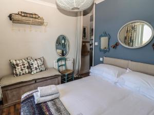 um quarto com uma cama, um sofá e um espelho em Starfish em Penzance