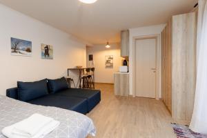 uma sala de estar com um sofá azul e uma cozinha em FAOS Properties em Kavala