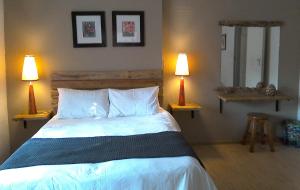 a bedroom with a large bed with two lamps at Angela's Guest House in Marico-Wes +10 photos
