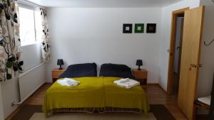 una camera da letto con un letto giallo con due asciugamani di Lagarfell Studios a Egilsstadir