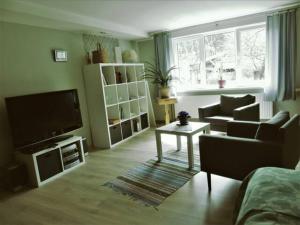 ein Wohnzimmer mit einem TV, einem Sofa und einem Tisch in der Unterkunft Holiday house with sauna in Riga