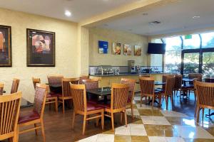 a restaurant with wooden tables and chairs and a counter at Wyndham Garden Newark Fremont Silicon Valley in Newark