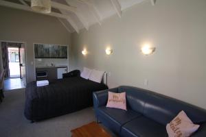 sala de estar con sofá negro en Apex on Fenton, en Rotorua