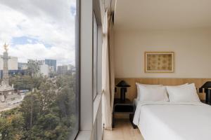 a bedroom with a window with a view of a city at Sonder Las Alas in Mexico City