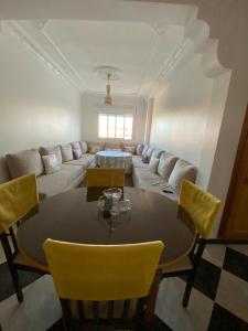 a living room with a table and yellow chairs at High quality appartement (4éme étage) in Martil