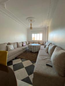 - un salon avec un canapé et une table dans l'établissement High quality appartement (4éme étage), à Martil