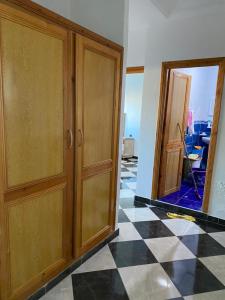 High quality appartement (4éme étage) في مرتيل: غرفة بها دواليب خشبية وارضية سوداء وبيضاء