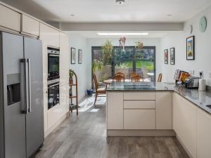 a kitchen with white cabinets and a table with chairs at Pass the Keys Cosy 3 Bed Cottage in Chorleywood in Chorleywood