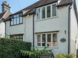 una casa de ladrillo blanco con ventanas y un seto en Pass the Keys Cosy 3 Bed Cottage in Chorleywood, en Chorleywood