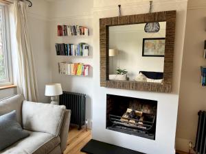 sala de estar con chimenea y espejo en Pass the Keys Cosy 3 Bed Cottage in Chorleywood, en Chorleywood