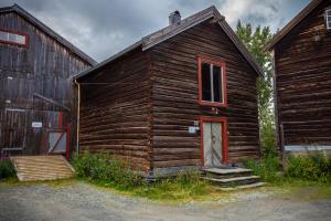 um antigo edifício de madeira com uma porta vermelha e um celeiro em Skanckegårdene AS em Røros