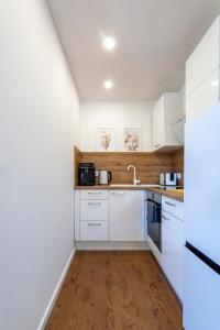 una cocina con armarios blancos y fregadero en Fabulous 2 Room City Apartment - 60 qm - Contactless Check-in, en Hannover