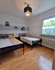 a bedroom with two beds and a window at 3 Zimmer-Apartment mit Terrasse in Gernsbach