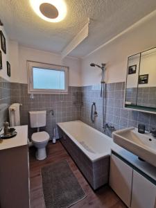 a bathroom with a tub and a toilet and a sink at 3 Zimmer-Apartment mit Terrasse in Gernsbach