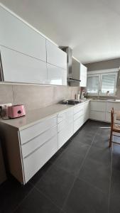 a kitchen with white cabinets and a counter top at Casa Polizzi - Maison entière in Fontaine-lʼÉvêque