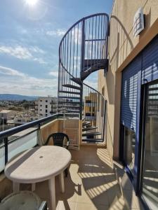 a balcony with a table and stairs on a building at Espectacular ático en Gandia, a 2 minutos de la playa in Bellreguart