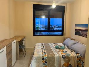a bedroom with a bed with a desk and a window at Espectacular ático en Gandia, a 2 minutos de la playa in Bellreguart +31 photos