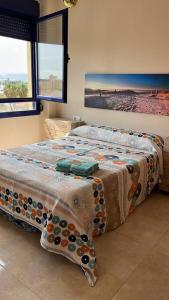 a bedroom with a bed with a blanket on it at Espectacular ático en Gandia, a 2 minutos de la playa in Bellreguart