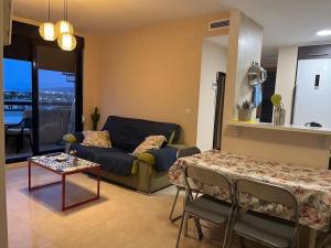 a living room with a couch and a table at Espectacular ático en Gandia, a 2 minutos de la playa in Bellreguart