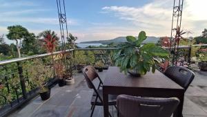 d'une table et de chaises sur un balcon orné de plantes. dans l'établissement Verano GuestHouse, à Tagbilaran