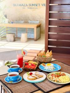 a table topped with plates of food and drinks at Taj Maza Sunset Villas in Gili Trawangan