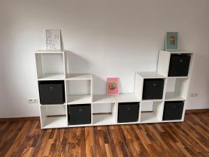 un estante de libros blanco en una habitación con pared en 4-h3rOeS Legoland Günzburg Wohnung 1, en Leipheim