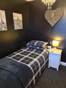 a bedroom with a bed and a heart on the wall at Dungarvon House B&B, Weston-super-Mare, Exclusive Bookings, Private Hot tub in Worle