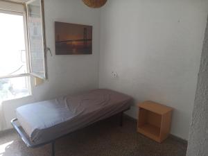 アリカンテにあるPensíon24Todoのベッドとテーブル付きの小さな部屋