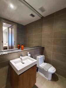 La salle de bains est pourvue d'un lavabo, de toilettes et d'un miroir. dans l'établissement C2004 Grand Medini Couple 100mbps Netflix By STAY, à Nusajaya