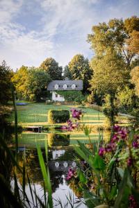 un giardino con laghetto e fiori di fronte a un fienile di Cottage house Lublin a Lublino