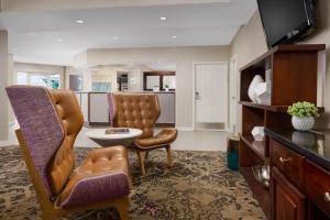 a living room with a chair and a table at Residence Inn Boston Foxborough in Foxborough