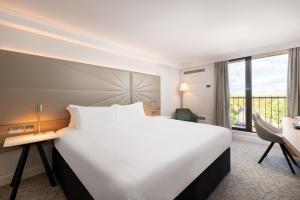 ビッケンヒルにあるヒルトン バーミンガム メトロポールの窓付きの客室で、白い大型ベッド1台が備わります。