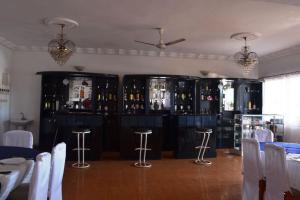 a room with a bar with black cabinets and stools at Austral Hotel in Farafangana