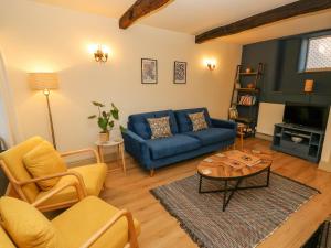 salon z niebieską kanapą i stołem w obiekcie Flora Cottage w mieście Buxton